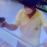 Ein einsamer Räuber bedroht während des Überfalls am Donnerstagmorgen Mitarbeiter des Goldgeschäfts Yaowarat Krungthep in einem Tesco Lotus-Einkaufszentrum in Pathum Thani mit einer Waffe.