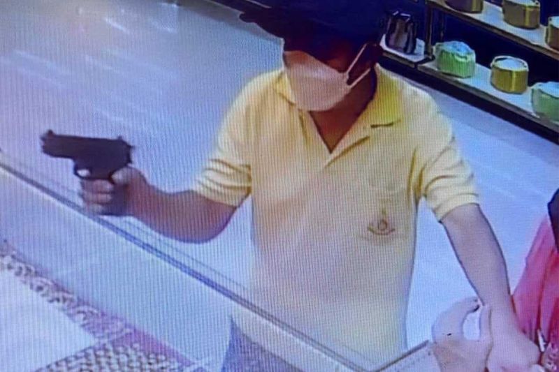 Ein einsamer Räuber bedroht während des Überfalls am Donnerstagmorgen Mitarbeiter des Goldgeschäfts Yaowarat Krungthep in einem Tesco Lotus-Einkaufszentrum in Pathum Thani mit einer Waffe.