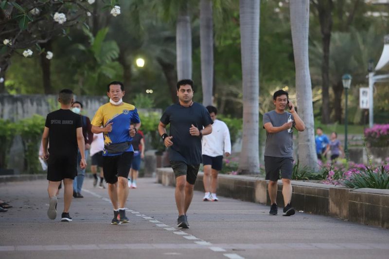 Menschen joggen ohne Gesichtsmasken im Benjakitti Park in Bangkok