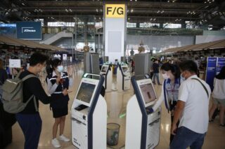 Passagiere bereiten sich am Flughafen Suvarnabhumi über Self-Check-in-Automaten auf den Abflug vor