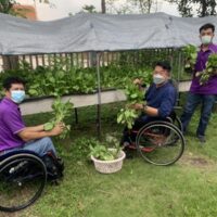 Prasert Laitim, links, Khuen Supanyabut, Mitte, und ein weiterer Mitarbeiter der Association of the Physically Handicapped in Pathum Thani zeigen ihre Produkte