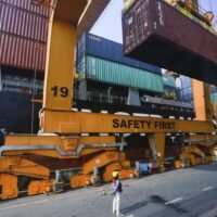 Versandcontainer werden im Hafen von Bangkok auf einen internationalen Frachter verladen. Die Baht-Abwertung macht thailändische Exporte billiger, importierte Rohstoffe werden jedoch teurer