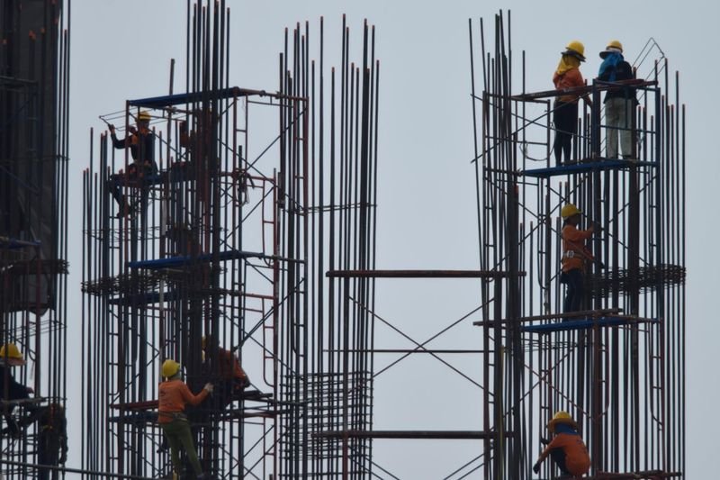 Arbeiter montieren Stahlstäbe auf einer Baustelle in Bangkok. Arbeiter montieren Stahlstäbe auf einer Baustelle in Bangkok.