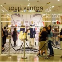 Chinesische Touristen stehen während eines Verkaufs vor einer Louis Vuitton-Boutique an, dem Kaufhaus Siam Paragon