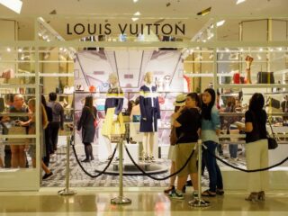 Chinesische Touristen stehen während eines Verkaufs vor einer Louis Vuitton-Boutique an, dem Kaufhaus Siam Paragon