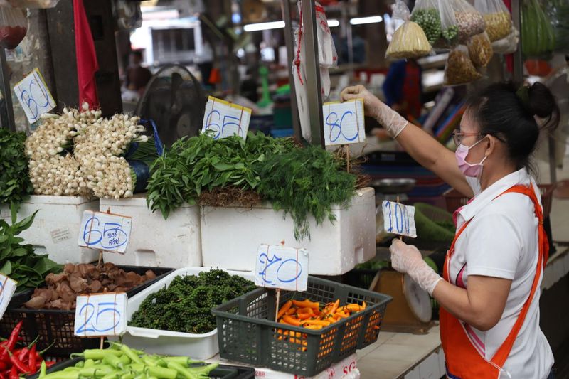 Ein Frischmarktverkäufer passt die Preise für Gemüse an, das auf dem Bang Kapi Markt in Bangkok verkauft wird. Forscher prognostizieren für die zweite Jahreshälfte 2022 eine höhere Inflation