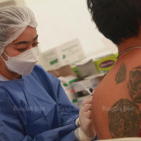 Ein medizinischer Mitarbeiter impft am 22. Februar 2022 einen Mann in der Provinzverwaltung von Samut Prakan in der Provinz Samut Prakan gegen Covid-19