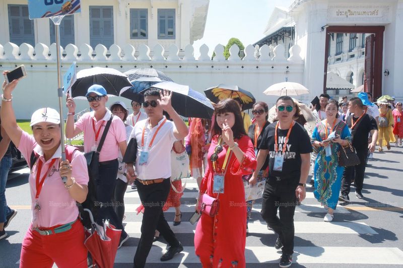 Eine Gruppe chinesischer Touristen besichtigt vor dem Ausbruch von Covid-19 den Grand Palace in Bangkok. Thailändische Reiseveranstalter hoffen, sie bald wieder begrüßen zu können.