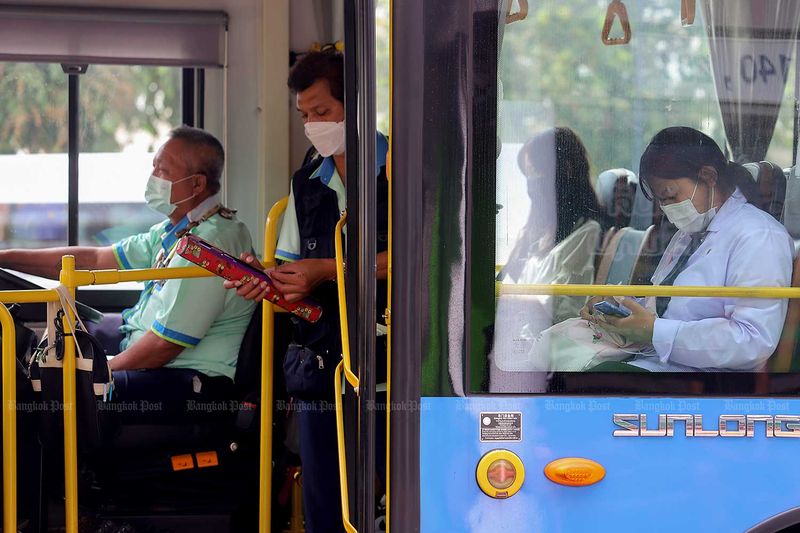 Passagiere in einem öffentlichen Bus in Bangkok tragen am Montag immer noch Gesichtsmasken, um sich vor Covid-19 zu schützen.