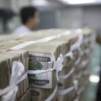 Stapel von Kyat sind auf dem Tresen zu sehen, bevor ein Kunde sie bei einer Bank in Yangon abholt