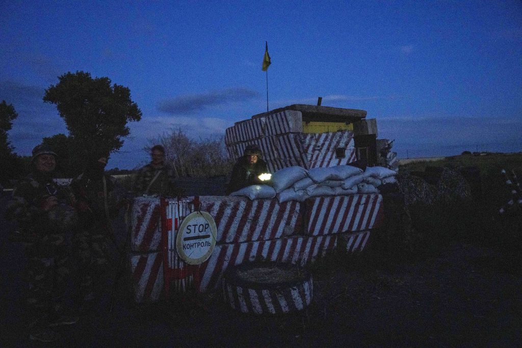 Ukrainische Soldaten stehen während der nächtlichen Ausgangssperre an einem Kontrollpunkt in der Region Donezk in der Ostukraine, Freitag, 22. Juli 2022