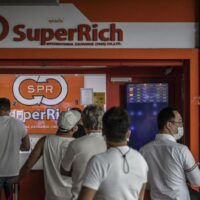 Kunden stehen Schlange vor einer Wechselstube in Bangkok