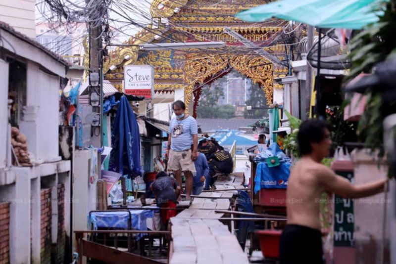 Die Bewohner überprüfen am Donnerstag die Stärke eines erhöhten Gehwegs durch ihre Gemeinde rund um Wat Thewarat Kunchorn im Stadtteil Dusit in Bangkok