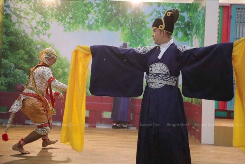 Ein Künstler präsentiert einen traditionellen koreanischen Tanz zusammen mit einem klassischen „Khon“-Tänzer während einer interkulturellen Kunstaufführung