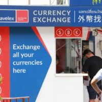 Ein Kunde tauscht Geld in einer Filiale von Travelex in Bangkok