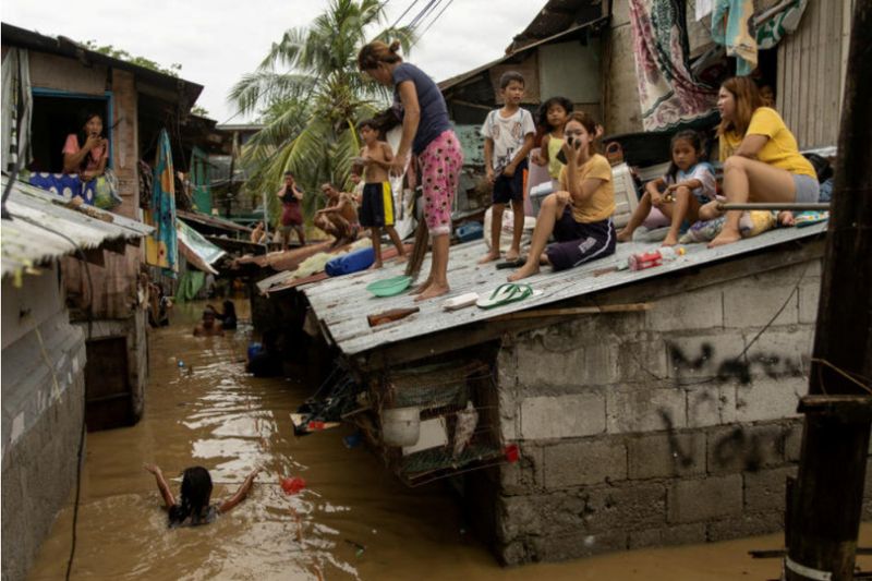 Einwohner von San Miguel in der Provinz Bulacan warten auf dem Dach ihrer Häuser darauf, dass die Überschwemmungen nachlassen,
