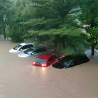 Hochwasser überschwemmt Autos, eines davon noch mit eingeschaltetem Licht, im Bezirk Thalang, Phuket, nach Stunden starken Regens am Freitagmorgen.
