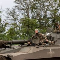 Ukrainische Soldaten fahren mit einem Panzer entlang einer Hauptstraße, während Russlands Angriff auf die Ukraine in der Stadt Izium weiter geht