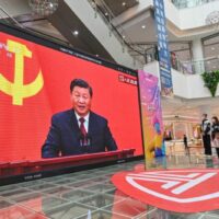 Die Menschen sehen sich am 23. Oktober in einem Einkaufszentrum in Qingzhou in der östlichen Provinz Shandong eine Live-Übertragung der Rede von Herrn Xi an