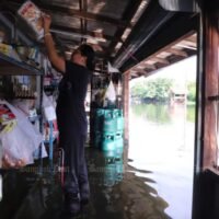 Ein Ladenbesitzer stellt am Dienstag inmitten des steigenden Überlaufs des Bang Yai-Kanals im Distrikt Bang Yai in der Provinz Nonthaburi Waren in höhere Regale