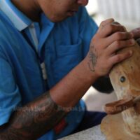 Ein ehemaliger Drogenabhängiger konzentriert sich auf ein Stück Holz, während er sich in einem Reha-Programm im Drogenrehabilitationszentrum im Distrikt Phunphin in Surat Thani unterzieht.