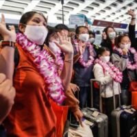 Passagiere, die Teil der ersten aus Thailand ankommenden Touristengruppe sind, posieren am Mittwoch am internationalen Flughafen Taoyuan in Taoyuan für die Medien