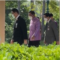 Premierminister Prayuth Chan-o-cha (Mitte) wird am Dienstag im Government House von Pirapan Salirathavibhaga (rechts) eng begleitet.