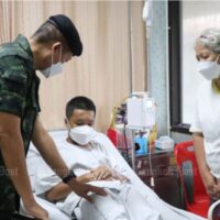 Der stellvertretende Kommandant der Armeeregion 4, Maj Gen Paisal Nusang, besucht einen Studenten in einem unbekannten Krankenhaus in Narathiwat, mit einem Elternteil an seiner Seite. Der Junge erkrankte am Montag nach einem Armeelehrgang