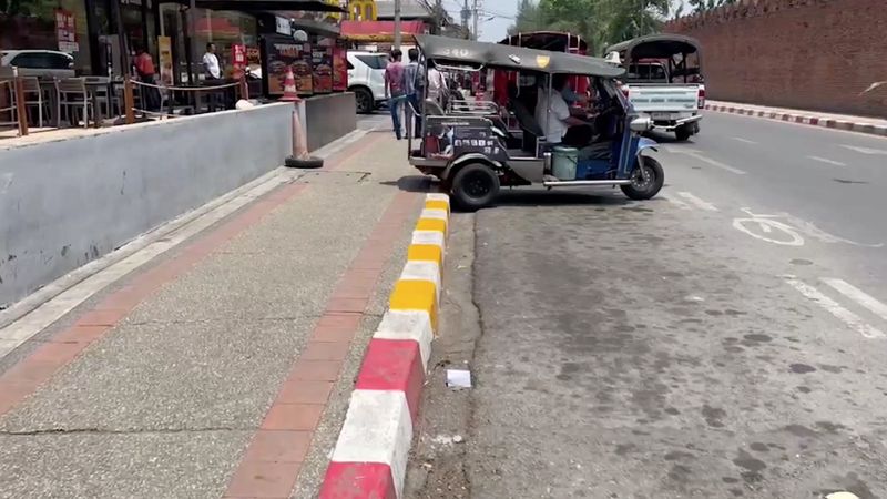 Geschickte Tuk-Tuk Fahrer wurden vor einer Kamera dabei erwischt, wie sie in Chiang Mai in Nordthailand gelbe Farbe über die roten Linien auf dem Bürgersteig strichen, damit sie ihre dreirädrigen Fahrzeuge neben dem Tha Phae Gate parken konnten, ohne Bußgelder zu erhalten. Rot-Weiß bedeutet absolutes Parkverbot, Gelb-Weiß bedeutet, dass dort vorübergehend geparkt werden darf.