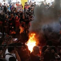 Wütende Unterstützer der Vereinigten Front von Thammasat und der Demonstrationsgruppe verbrennen am Mittwoch Bildnisse vor dem Hauptquartier der Pheu-Thai-Partei, nachdem sie erfahren haben, dass sich die Pheu-Thai-Partei aus der Koalition zurückgezogen hat, in dem Versuch, eine Regierung ohne die wahlsiegende Move Forward-Partei zu bilden. (Foto: Wichan Charoenkiatpakul)