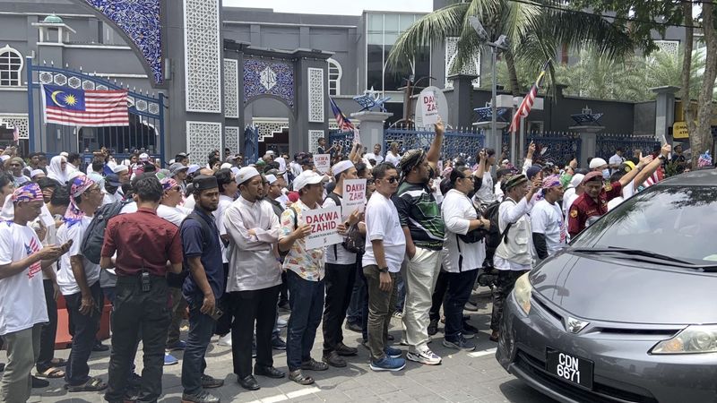 Hunderte Menschen veranstalteten am Samstag in der malaysischen Hauptstadt eine Kundgebung gegen die Regierung und beschuldigten Premierminister Anwar Ibrahim , seinem wichtigsten Verbündeten im Gegenzug für politische Unterstützung geholfen zu haben, der Strafverfolgung zu entgehen.