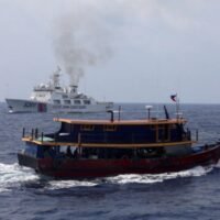 Ein philippinisches Versorgungsboot fährt am 4. Oktober 2023 während einer Nachschubmission für philippinische Truppen, die auf einem auf Grund liegenden Kriegsschiff im Südchinesischen Meer stationiert sind, in der Nähe eines Schiffes der chinesischen Küstenwache. (Foto: Reuters)