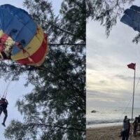 Ein ausländischer Tourist geriet in eine prekäre Situation, als sein Parasailing- Abenteuer schiefging und er auf einer 5 Meter hohen Kiefer am Kamala Beach in Phuket festsaß . Die Polizei wurde zur Unfallstelle gerufen, um ihn mit einem Kranwagen zu retten.