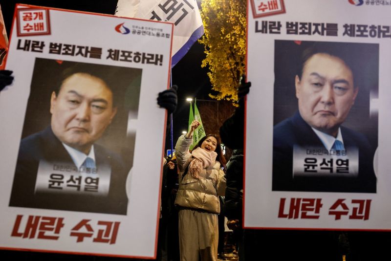 Demonstranten halten während einer Mahnwache bei Kerzenlicht riesige Plakate hoch, um den Rücktritt des südkoreanischen Präsidenten Yoon Suk Yeol am Donnerstagabend in Seoul zu fordern.