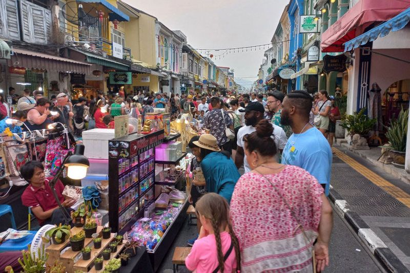 Touristen besuchen eine Fußgängerzone in der Altstadt von Phuket. Die Provinz erwartet zwischen dem 28. Dezember und dem 1. Januar Einnahmen von fast 8 Milliarden Baht durch mehr als 230.000 Besucher, sagt Lertchai Wangtrakuldee, Direktor des Phuket-Büros der thailändischen Tourismusbehörde. (Foto: Achadthaya Chuenniran)
