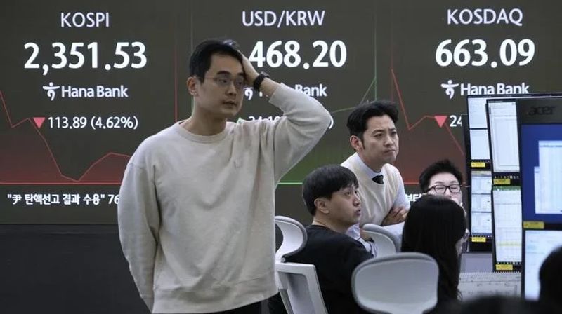 Devisenhändler beobachten Monitore in der Nähe eines Bildschirms, der den Korea Composite Stock Price Index (KOSPI) (oben links) und den Wechselkurs zwischen US-Dollar und südkoreanischem Won (oben in der Mitte) im Devisenhandelsraum der KEB Hana Bank-Zentrale in Seoul, Südkorea, heute, am 7. April 2025, zeigt. Fotos: AP/Ahn Young-joon/ Foto oben veröffentlicht von The Atlanta Journal Constitution, Foto auf der Titelseite veröffentlicht von WPRI.com12