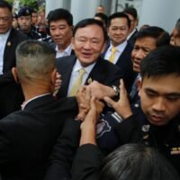 Der ehemalige Premierminister Thaksin Shinawatra lächelt seinen Anhängern zu, als er am Freitagmorgen das Strafgericht verlässt, nachdem er in seinem Majestätsbeleidigungsverfahren freigesprochen wurde. (Foto: Nutthawat Wichieanbut)