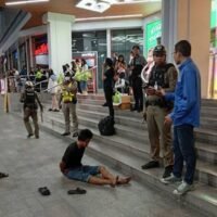 Varakorn Pubthaisong sitzt auf dem Bürgersteig vor dem Einkaufszentrum Big C in der Ratchadamri Road in Bangkok, nachdem er am Donnerstagabend zwei malaysische Touristen angezündet hat. (Foto: Polizei über Wassayos Ngamkham)
