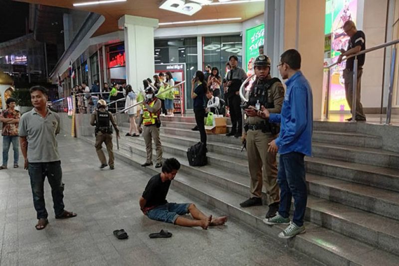 Varakorn Pubthaisong sitzt auf dem Bürgersteig vor dem Einkaufszentrum Big C in der Ratchadamri Road in Bangkok, nachdem er am Donnerstagabend zwei malaysische Touristen angezündet hat. (Foto: Polizei über Wassayos Ngamkham)