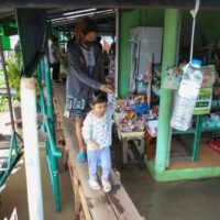 Bewohner gehen auf einem provisorischen Gehweg in der Gemeinde Bang Talat 1-Pak Dan in Pak Kret, Provinz Nonthaburi, nachdem der Wasserstand des Chao Phraya-Flusses gestiegen ist und die Gemeinden an seinen Ufern überschwemmt hat. Varuth Hirunyatheb