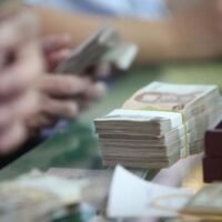 Ein Angestellter zählt Bündel von 1000-Baht-Banknoten. Der Baht habe ein Niveau erreicht, das Thailands Wirtschaftsstruktur, die von Nettoexporten getrieben sei, nicht mehr verkraften könne, so der amtierende Finanzminister Ekniti Nitithanprapas. (Foto: Apichart Jinakul)