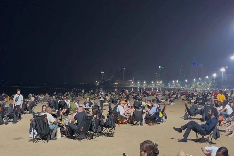 Thailändische und ausländische Touristen entspannen sich am Strand von Pattaya, da die Unterhaltungsstätten am Sonntag wegen der vorzeitigen Stimmabgabe geschlossen warenLaut Wahlgesetz muss der Verkauf alkoholischer Getränke ab 18 Uhr am Vorabend einer Wahl bis 18 Uhr am Wahltag eingestellt werden. Dementsprechend wurden alle Lokale, Bars und Restaurants, in denen alkoholische Getränke erhältlich waren, geschlossen.